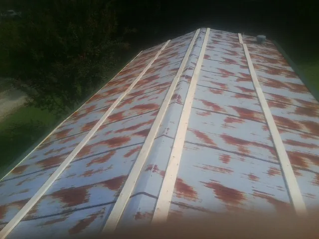 Rusted metal roof panels with new wood purlins before replacement — Storm Damage Roof Repair in Toulon by Roofing Brothers