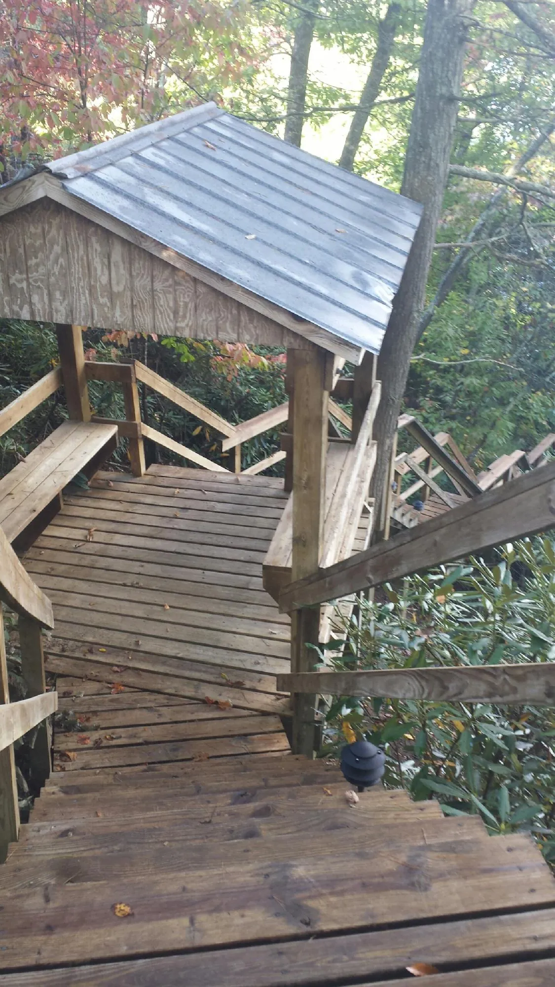 Metal roofed shelter over wooden steps on a wooded walkway — Skylight Repair & Installation work by our crew in Toulon