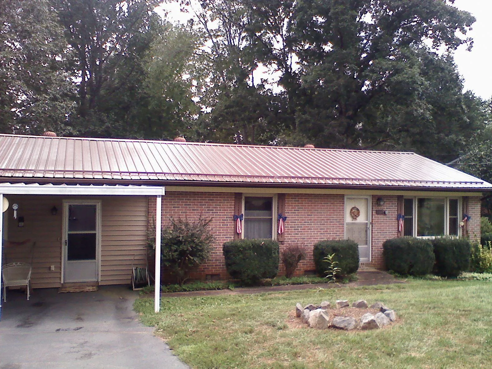 Bronze metal roof and carport on a brick ranch home — Roof Repair work by our crew in Toulon